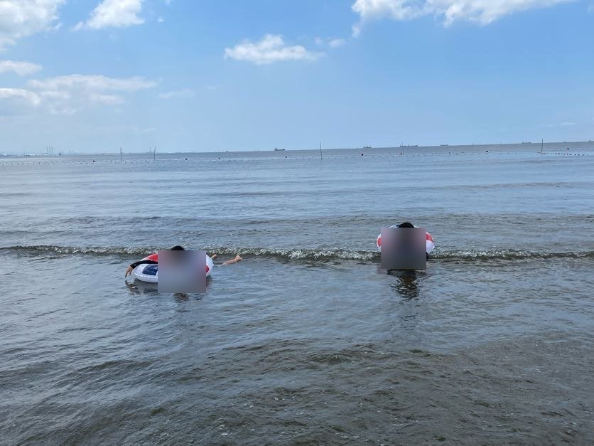 いなげの浜のおだやかな海で浮き輪遊びをする子ども