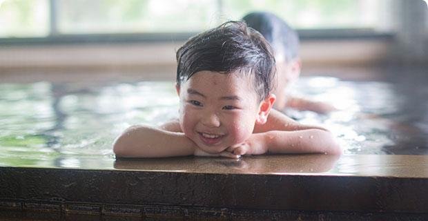 亀山温泉ホテルの黒湯温泉に入る子ども